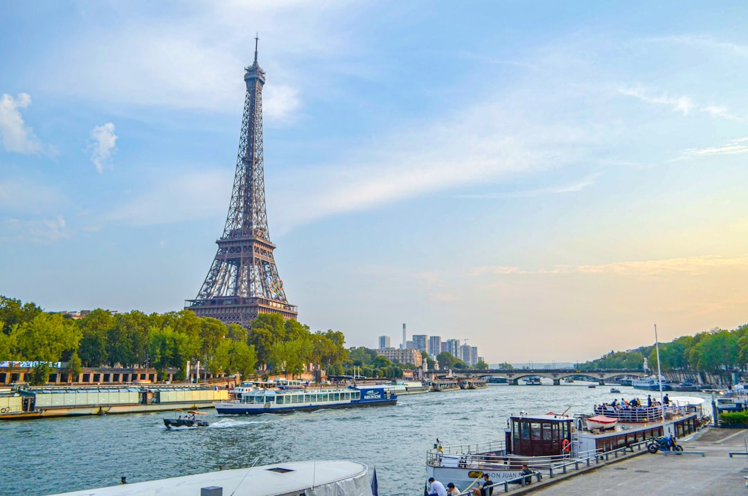 Eiffel tower and seine river with boats on a sunny day