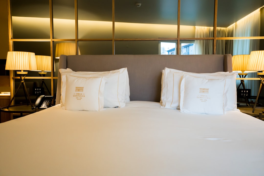 A neatly made bed with white pillows and lamps.